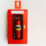 Fire,Extinguisher,In,Red,Cabinet,On,White,Wall,At,Exterior