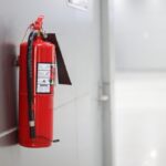 A,Red,Fire,Extinguisher,Hangs,On,The,Wall.