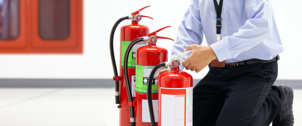 Office,Man,Checking,The,Handle,Of,The,Red,Fire,Extinguishers